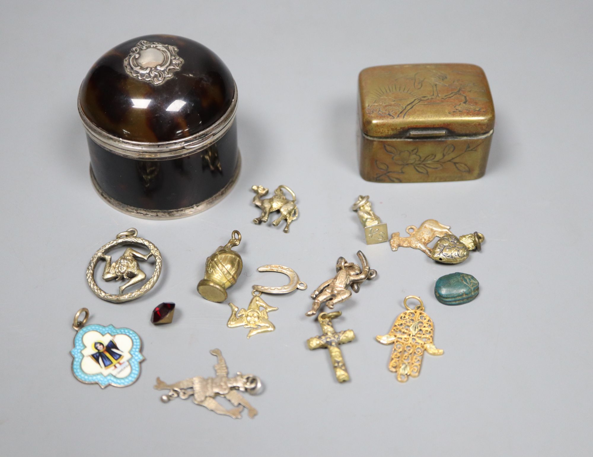 A late Victorian silver mounted tortoiseshell box, (a.f.) one other base metal box and a group of assorted metal charms.